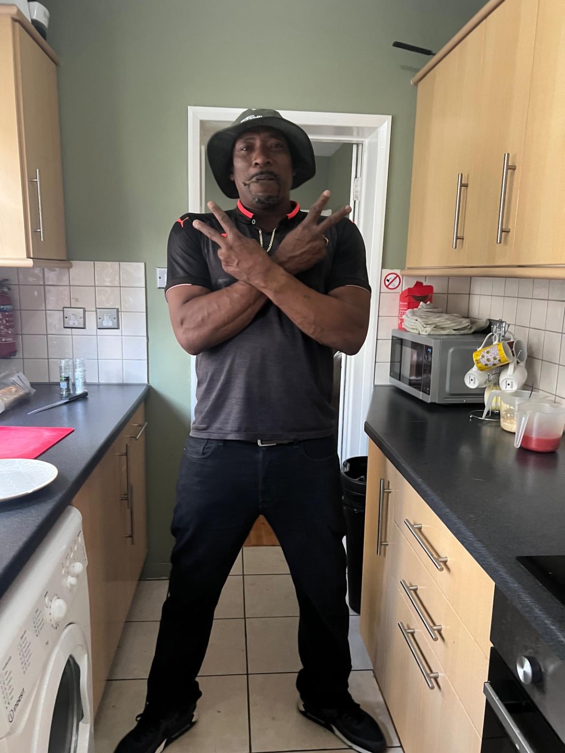 Stephen Hilton standing with crossed arms and a hat