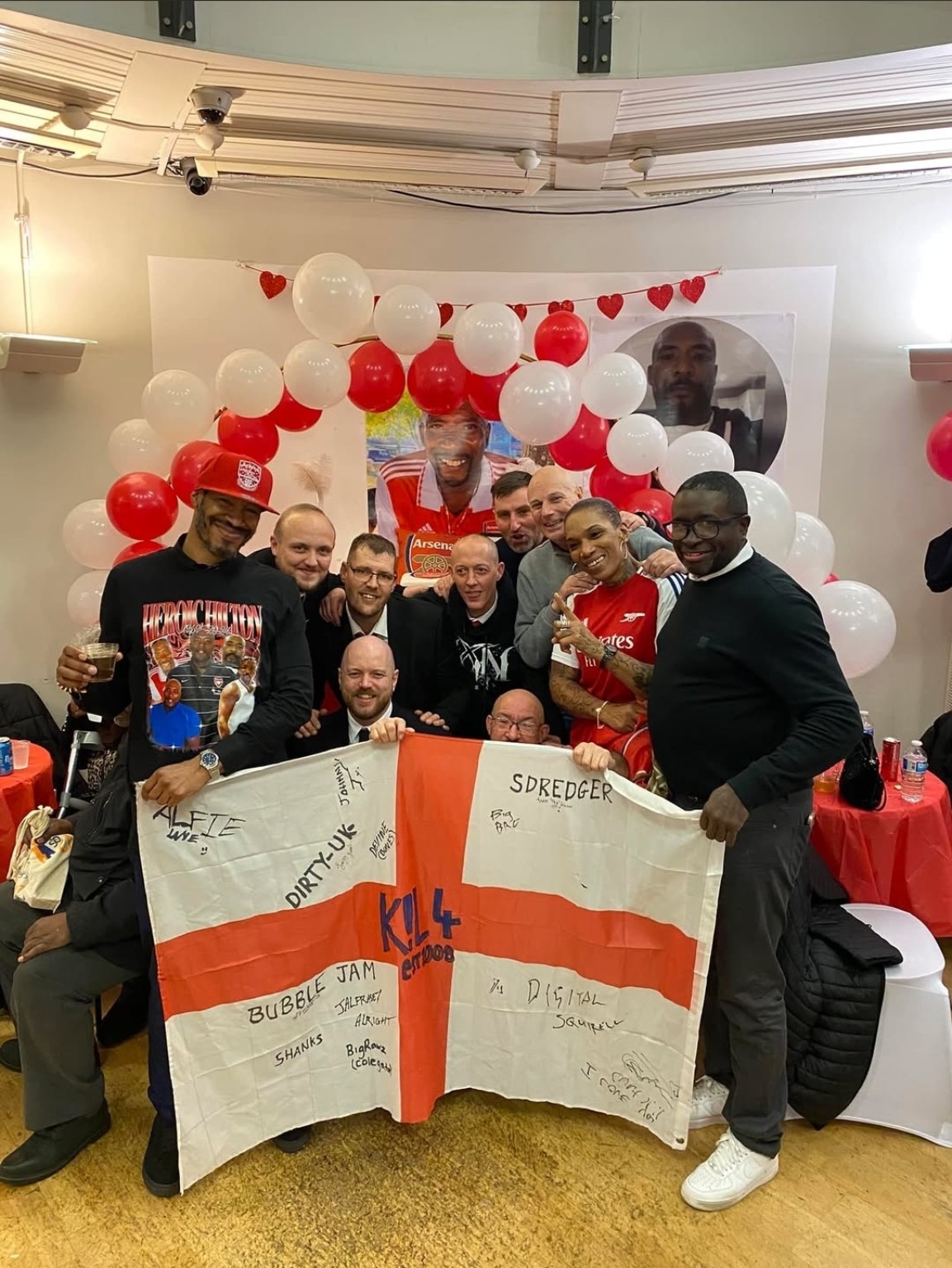 K!L4 members together at The Guvnor's wake holding a signed St George flag